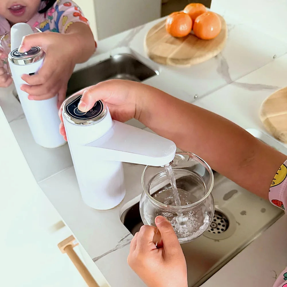 Child filling a glass jug from the working tap